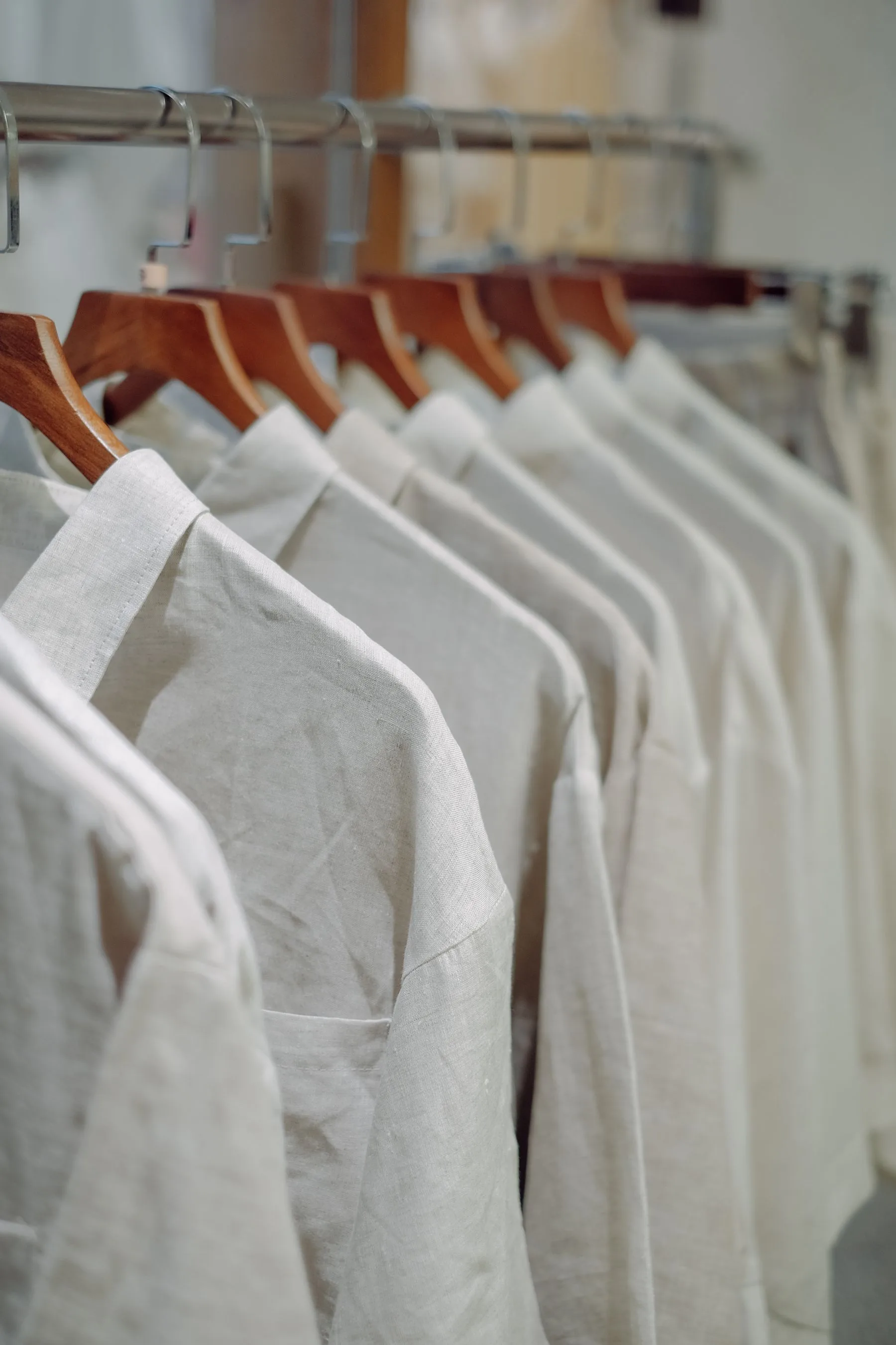 Camisas claras penduradas em uma arara de loja